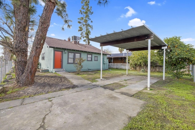 bungalow-style house featuring a carport, cooling unit, fence, and entry steps