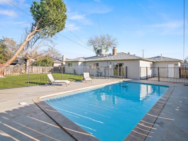 view of pool with cooling unit, fence, a yard, a fenced in pool, and a patio area