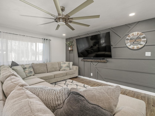 living room featuring a decorative wall, wood finished floors, a ceiling fan, and recessed lighting