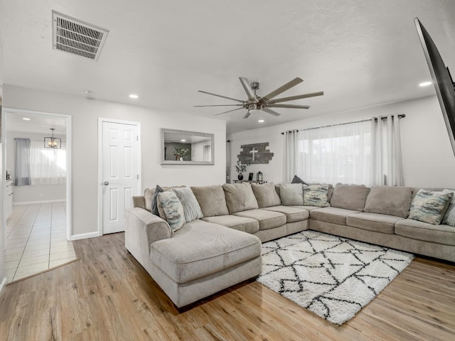 living area with recessed lighting, visible vents, ceiling fan, wood finished floors, and baseboards