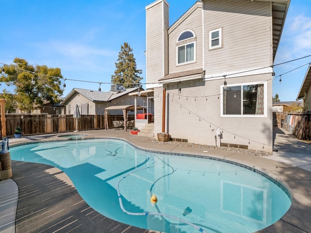 view of swimming pool with a fenced in pool, a patio area, fence, and an in ground hot tub