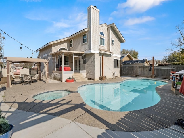 back of property with a chimney, a patio area, a fenced backyard, and a fenced in pool