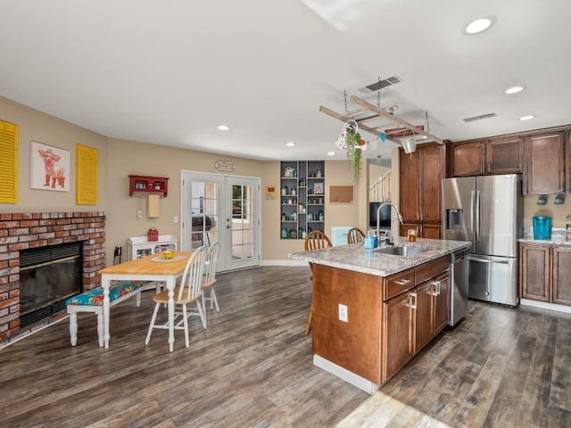 kitchen featuring visible vents, dark wood finished floors, appliances with stainless steel finishes, french doors, and a sink