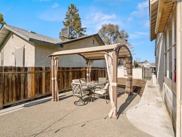 view of patio featuring outdoor dining space, a fenced backyard, and central air condition unit