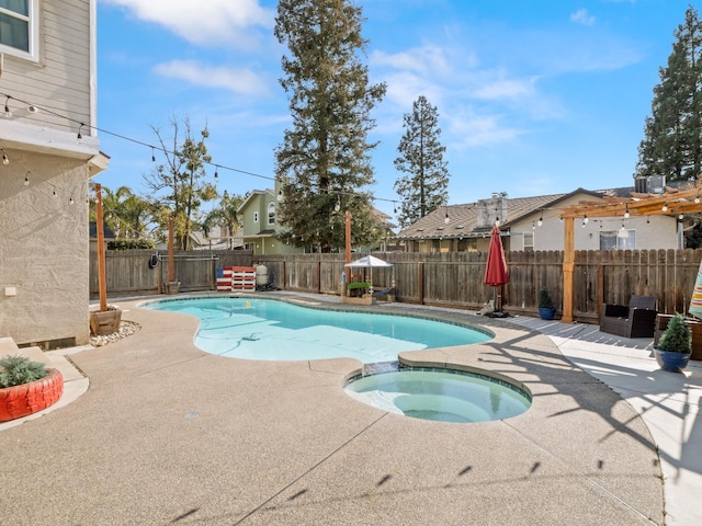 view of swimming pool with a patio area, a fenced backyard, and a pool with connected hot tub