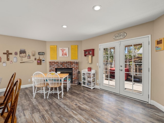 dining area featuring french doors, recessed lighting, a brick fireplace, wood finished floors, and baseboards