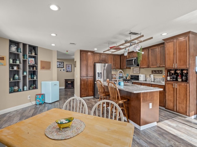 kitchen featuring an island with sink, light wood-style floors, visible vents, and appliances with stainless steel finishes