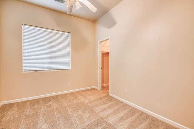 carpeted empty room with baseboards and a ceiling fan