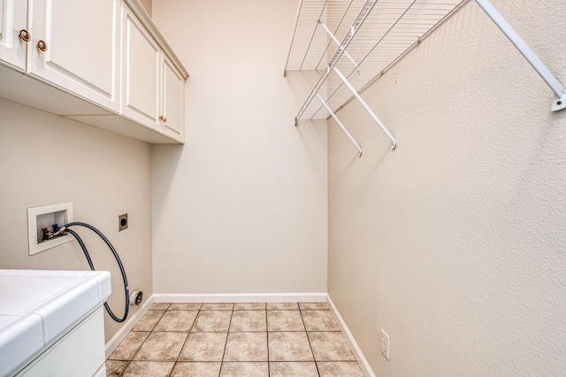 laundry area featuring hookup for a washing machine, cabinet space, baseboards, and light tile patterned floors