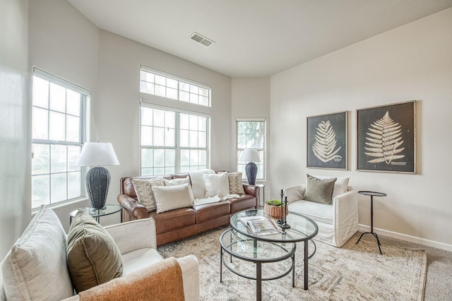 living room featuring light carpet, visible vents, and baseboards