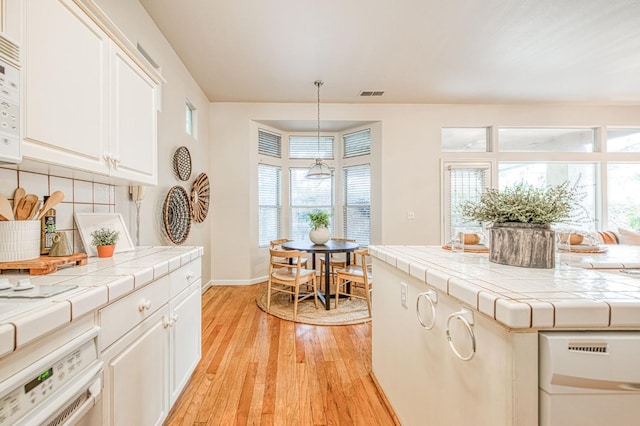 interior space with light wood finished floors, baseboards, and visible vents