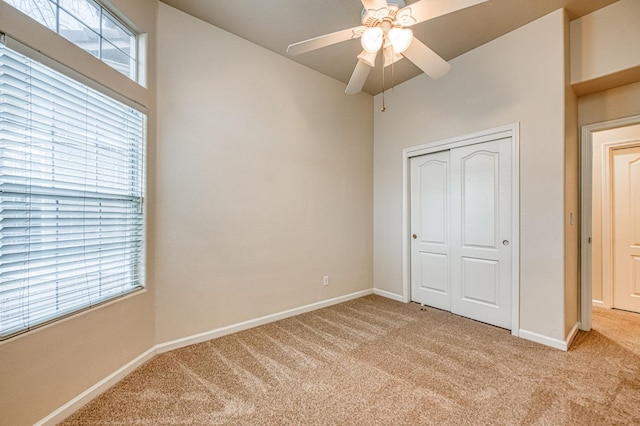 unfurnished bedroom featuring light carpet, a closet, and baseboards