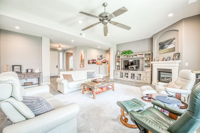 living room featuring arched walkways, recessed lighting, carpet floors, a fireplace, and visible vents