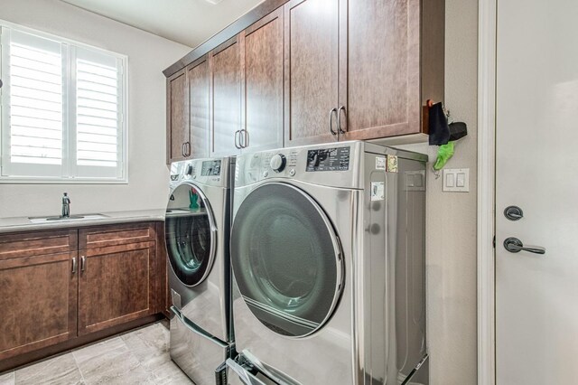 laundry room featuring a sink, cabinet space, and washer and dryer