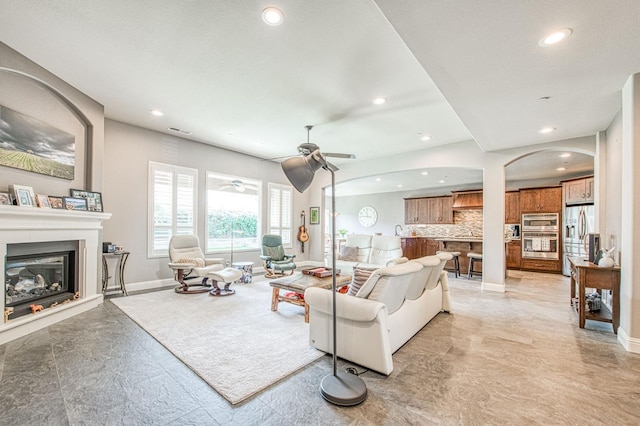 living area with recessed lighting, a ceiling fan, visible vents, baseboards, and a glass covered fireplace