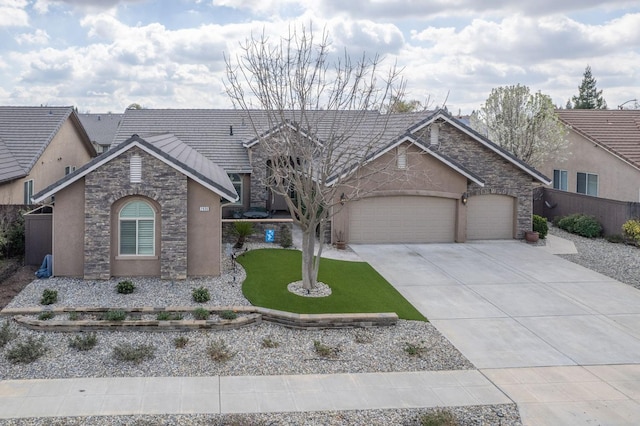 view of front of property with stone siding, stucco siding, an attached garage, and concrete driveway