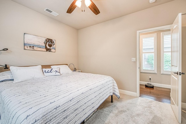 bedroom with ceiling fan, carpet flooring, visible vents, and baseboards