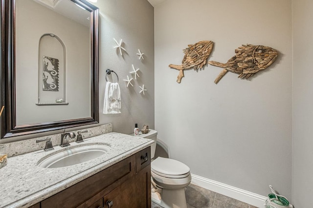 bathroom featuring toilet, tile patterned floors, vanity, and baseboards