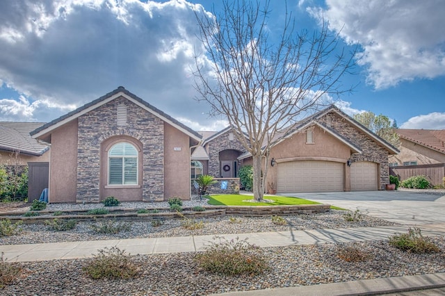 view of front of home featuring stucco siding, concrete driveway, an attached garage, fence, and stone siding