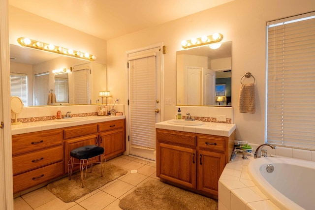 full bathroom with two vanities, tile patterned flooring, a sink, and a bath