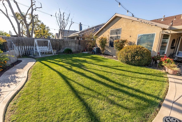 view of yard with central AC and a fenced backyard