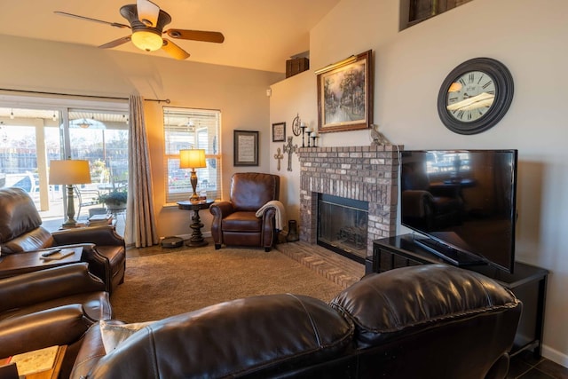 living area with a ceiling fan, a brick fireplace, and carpet floors