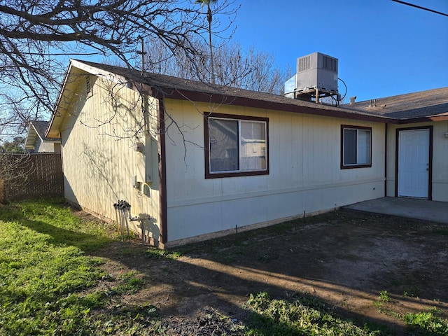 view of property exterior with a patio area, cooling unit, and fence