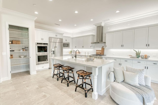 kitchen with built in appliances, decorative backsplash, wall chimney exhaust hood, a kitchen bar, and crown molding