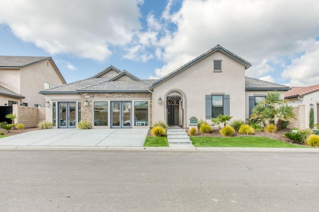 view of front of property featuring french doors, a tile roof, fence, and stucco siding