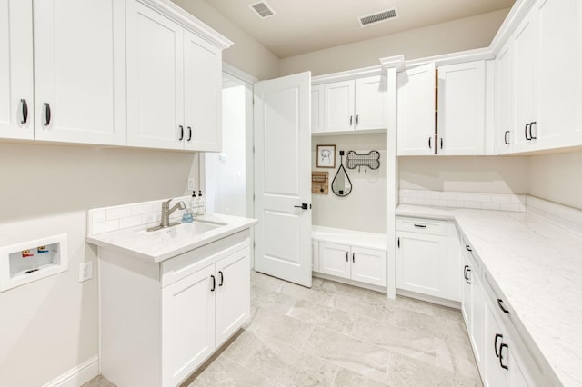 washroom featuring visible vents, a sink, hookup for a washing machine, and cabinet space