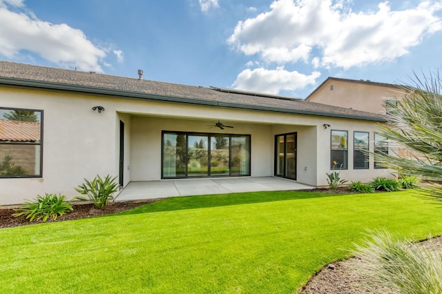 rear view of house with a yard, a patio area, ceiling fan, and stucco siding