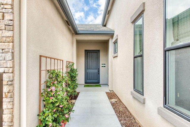 doorway to property featuring stone siding and stucco siding