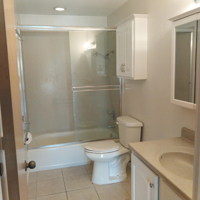 bathroom featuring combined bath / shower with glass door, vanity, toilet, and tile patterned floors