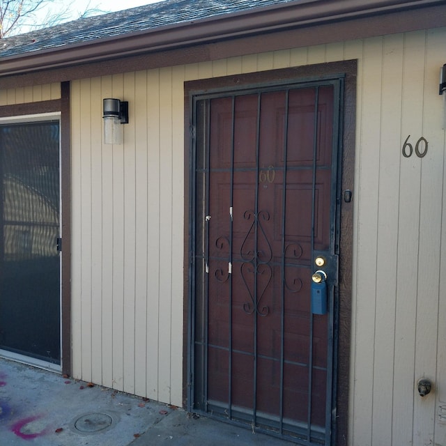 entrance to property with a shingled roof