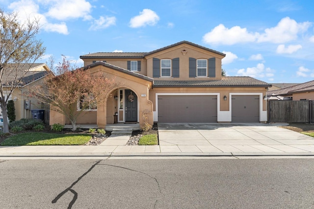 view of front of home featuring a tile roof, stucco siding, fence, a garage, and driveway