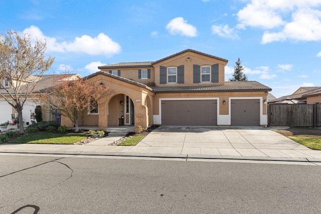 mediterranean / spanish-style home with fence, a tiled roof, and stucco siding