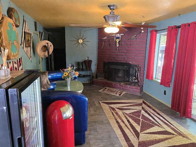 living area featuring a textured ceiling, a fireplace, a ceiling fan, and baseboards