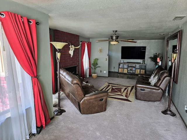 carpeted living room featuring a brick fireplace, visible vents, ceiling fan, and a textured ceiling