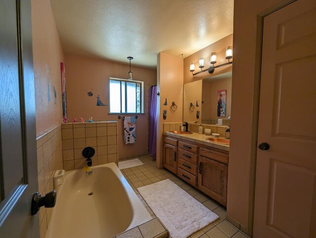 bathroom featuring tile patterned floors, a garden tub, a sink, and double vanity