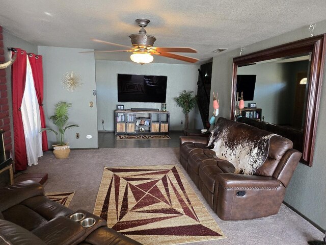 living room with a textured ceiling, ceiling fan, carpet, and visible vents