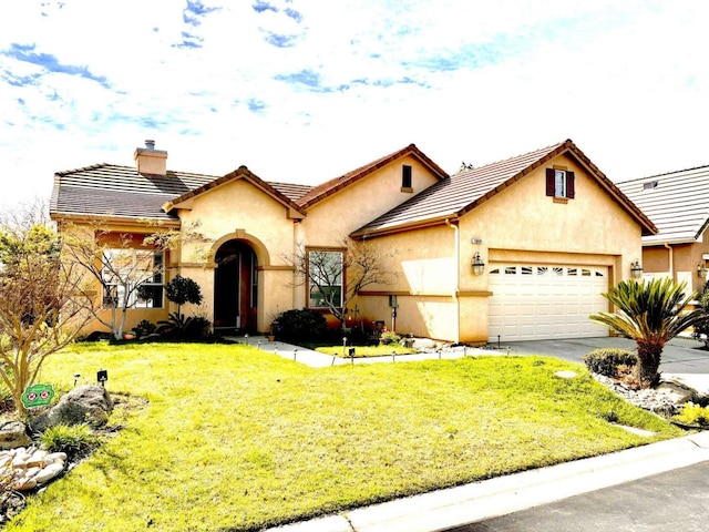 mediterranean / spanish home featuring a chimney, stucco siding, a garage, driveway, and a front lawn