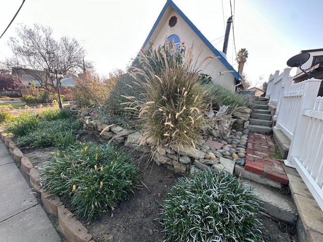 view of side of home with fence and stucco siding