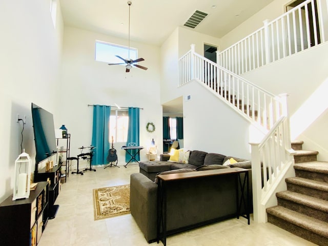 living room with ceiling fan, stairway, plenty of natural light, and visible vents