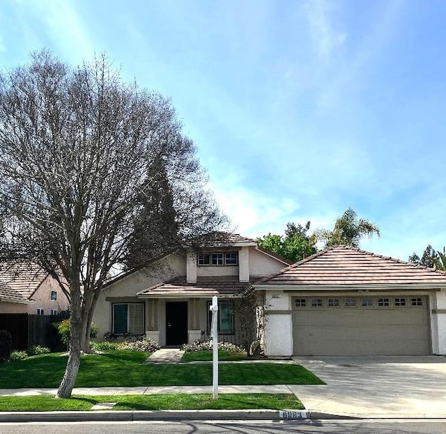 view of front facade with an attached garage, stucco siding, a front lawn, concrete driveway, and a tile roof