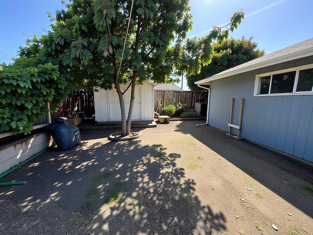 view of yard featuring an outbuilding, a storage shed, and a fenced backyard