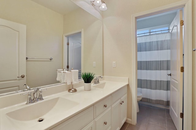 full bathroom featuring double vanity, toilet, tile patterned flooring, and a sink