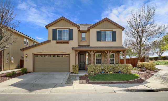 view of front of property with concrete driveway, an attached garage, fence, and stucco siding