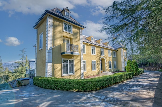 view of front of home featuring a balcony and stucco siding