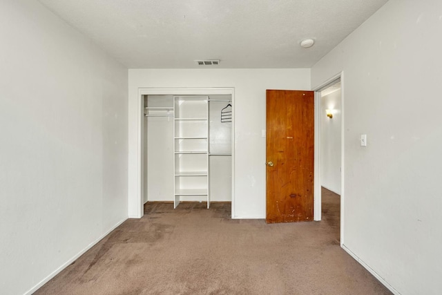 unfurnished bedroom with visible vents, carpet, a closet, and baseboards