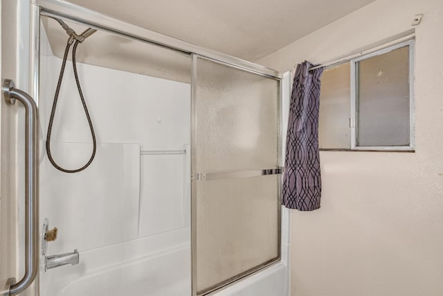 bathroom with combined bath / shower with glass door